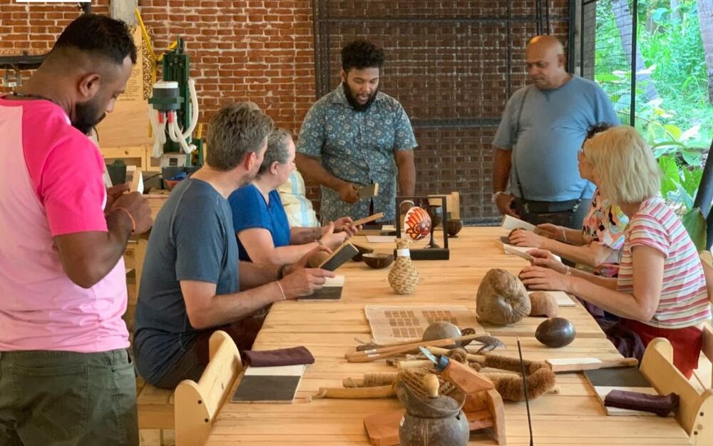 Handmade coconut shell bowls, cups and carved pieces laid out along the studio bench.