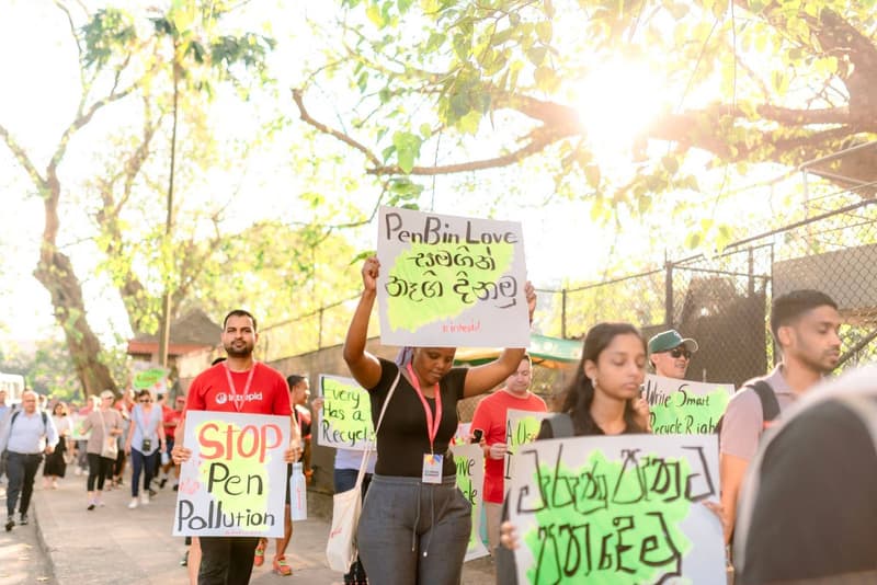 Campaigners walking with placards reading Stop Pen Pollution and PenBin Love during a ZeroPlastic awareness march.