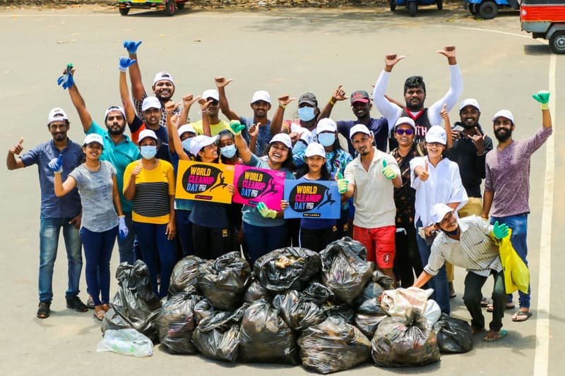 A large group of ZeroPlastic volunteers celebrating beside bags of waste collected on World Cleanup Day in Sri Lanka.