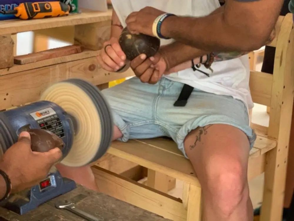 A sanded coconut shell being buffed to a smooth finish.