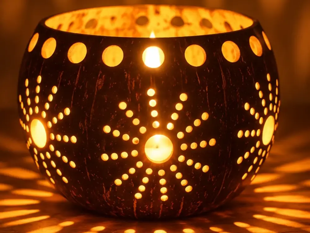 A visitor holding their finished, glowing coconut shell lamp.
