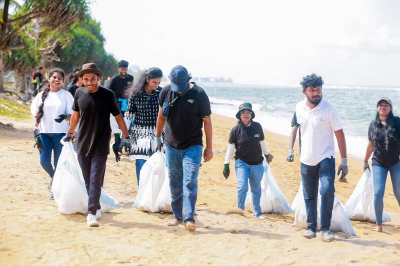 ZeroPlastic volunteers walking along a beach with collection sacks during a clean-up campaign.
